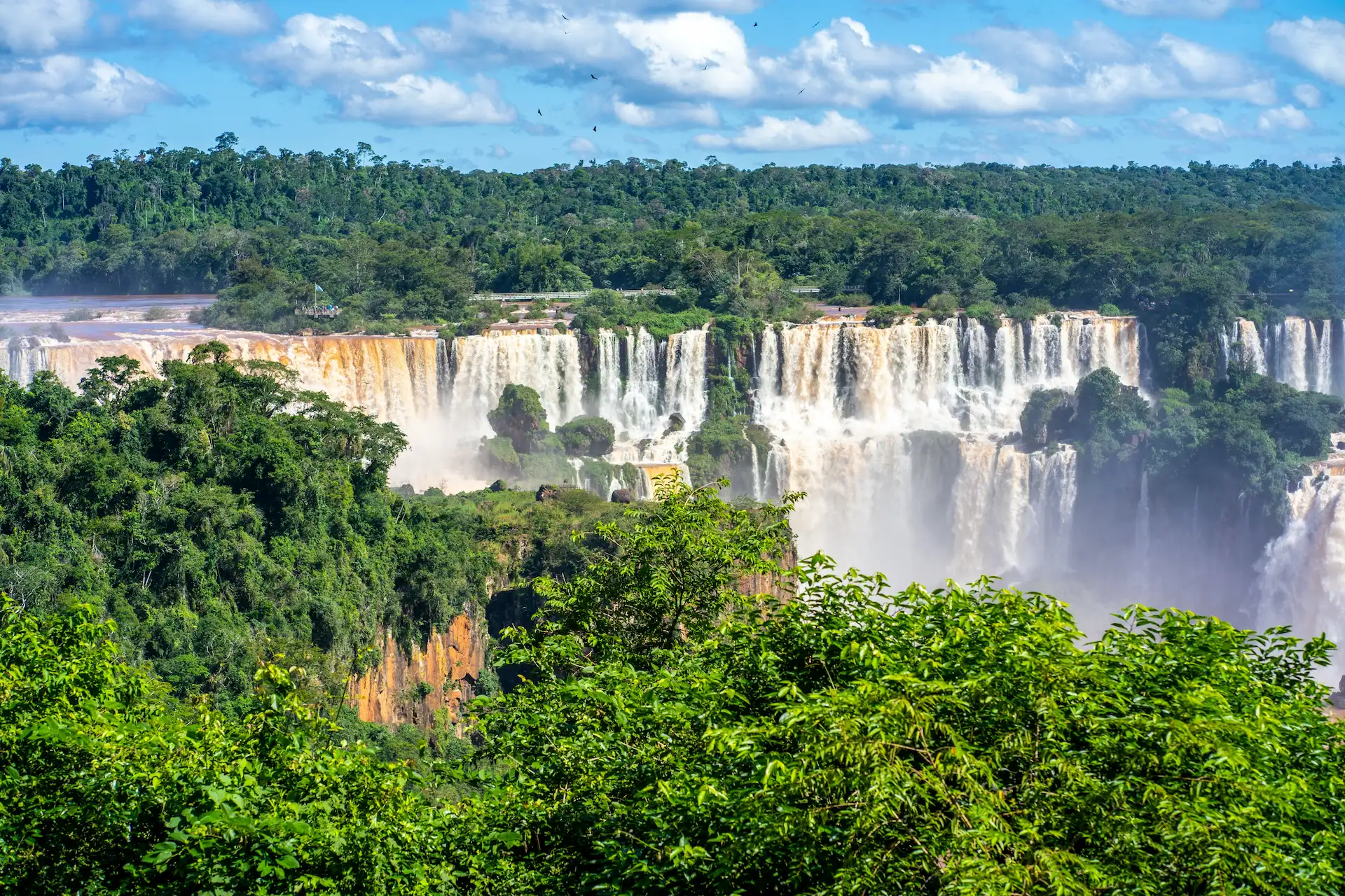 The Iguazú Falls and the surrounding rainforest seen from above on a clear day
