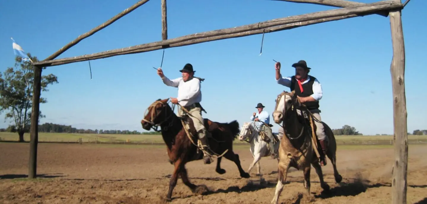 Gauchos on horseback by the corral gate of an estancia in the Buenos Aires pampas