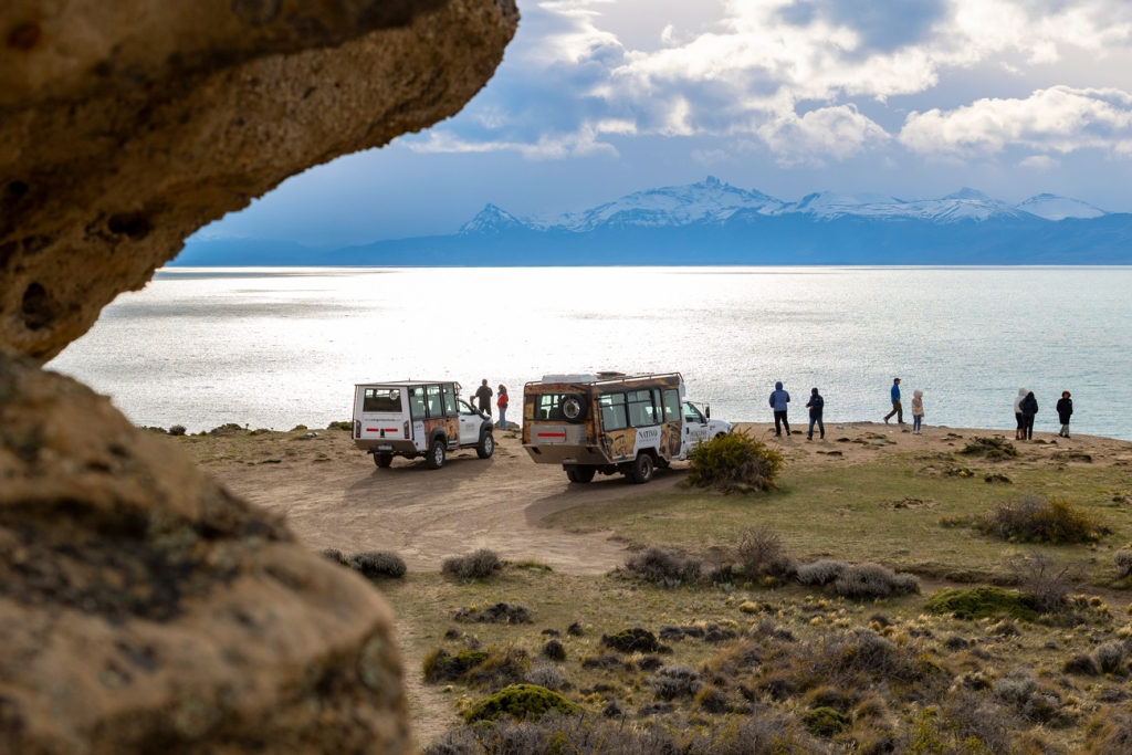 View of Lago Argentino and the snow-capped Andes framed by the mouth of a sandstone cave