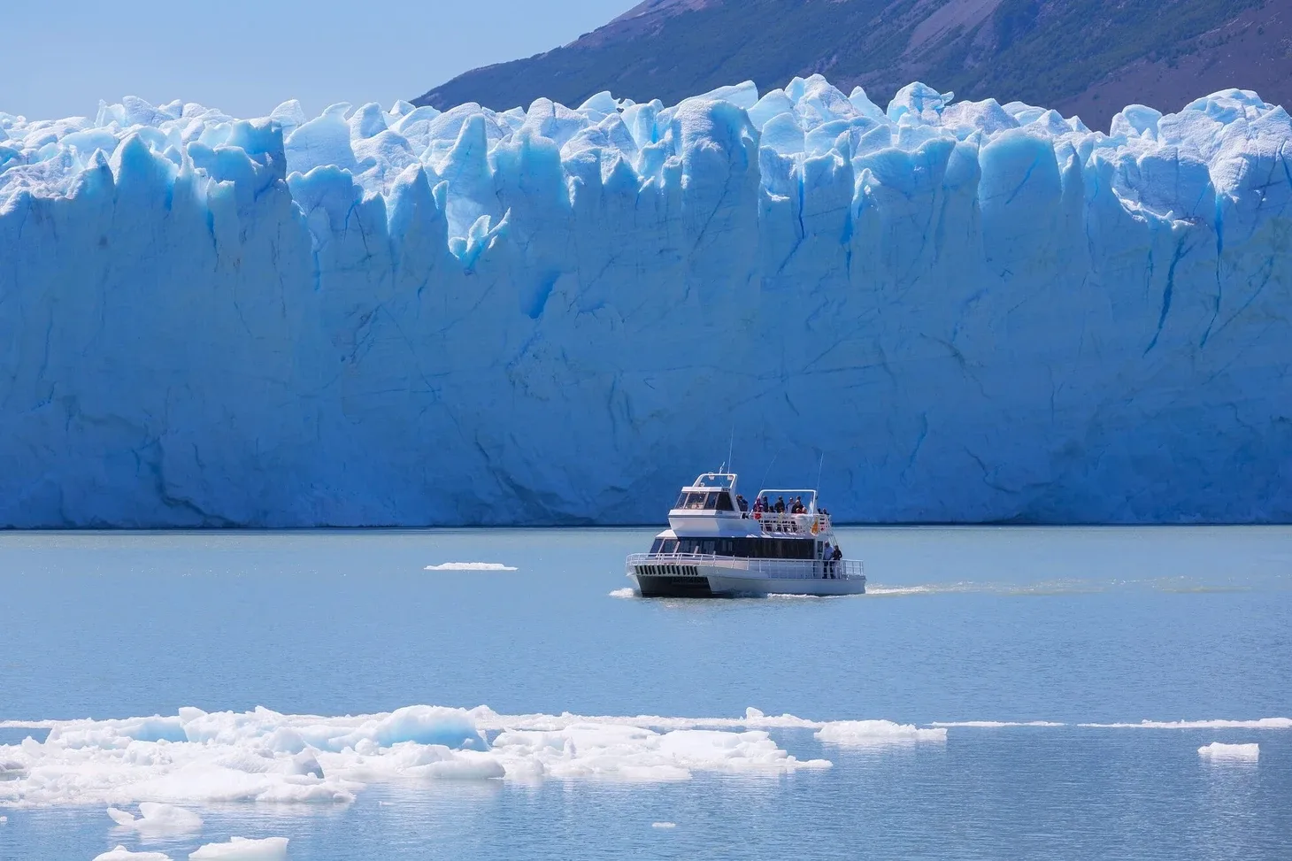A catamaran in front of the ice wall of the Perito Moreno Glacier during the nautical safari