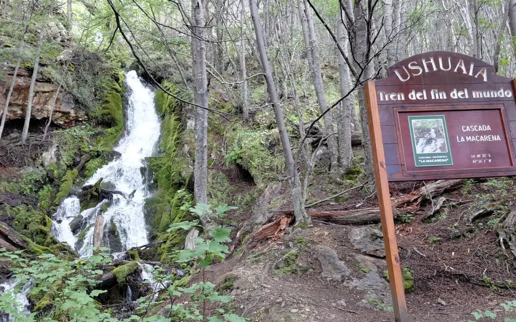 The La Macarena waterfall in Tierra del Fuego National Park, with the trail sign beside it