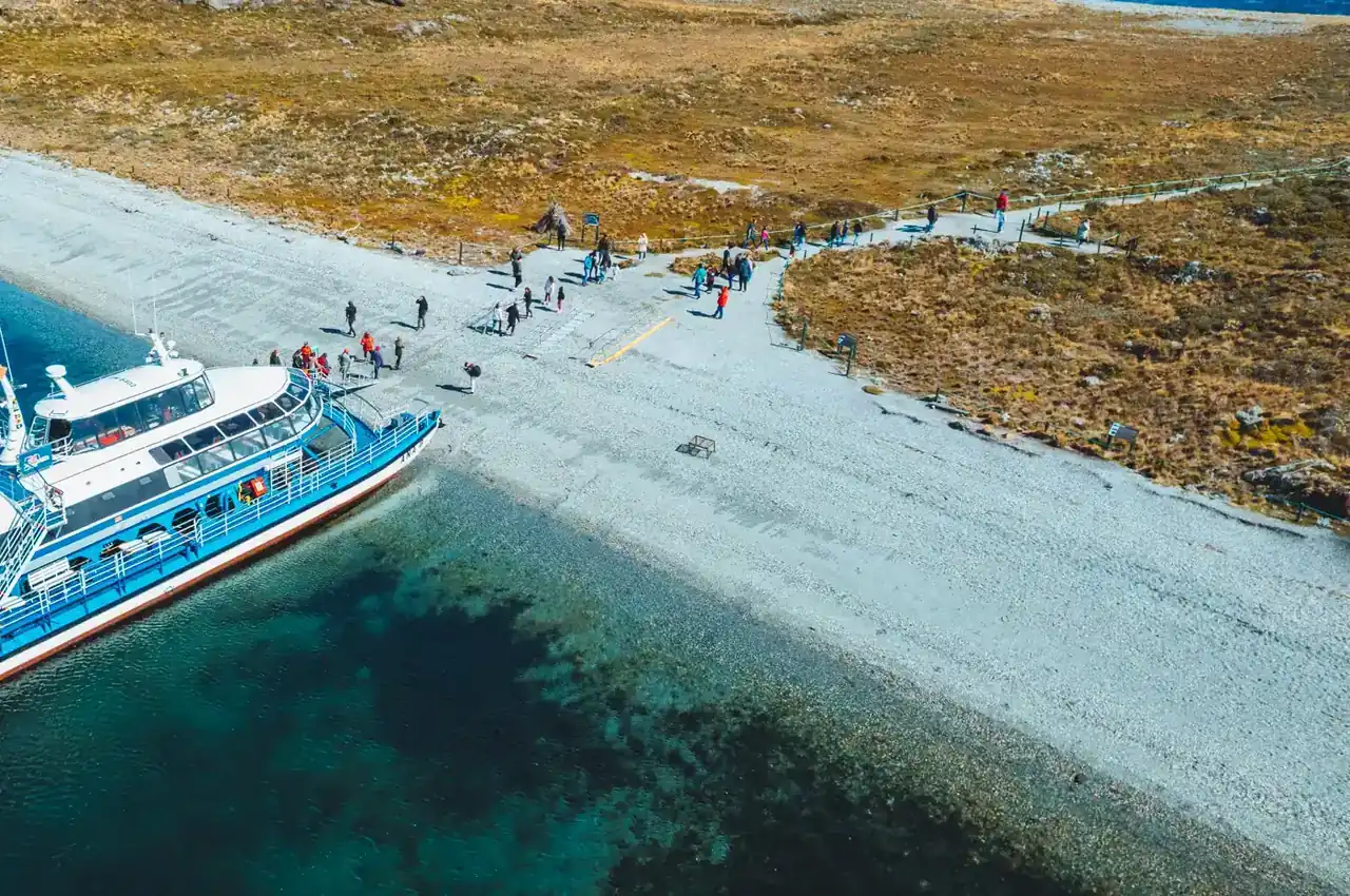Aerial view of a catamaran landing passengers on an island in the Bridges archipelago, Beagle Channel, Ushuaia