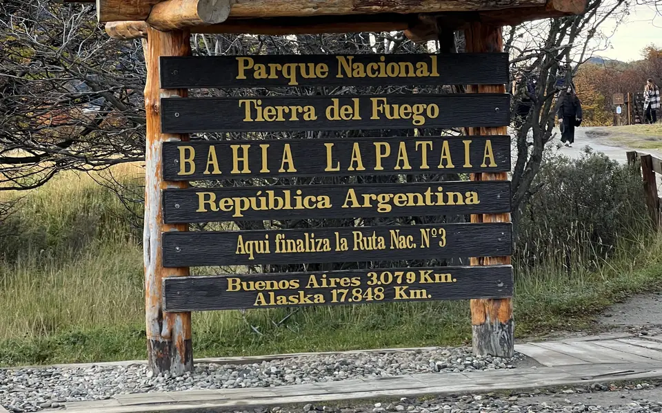 The wooden sign at Lapataia Bay marking the end of National Route 3, with the distances to Buenos Aires and Alaska