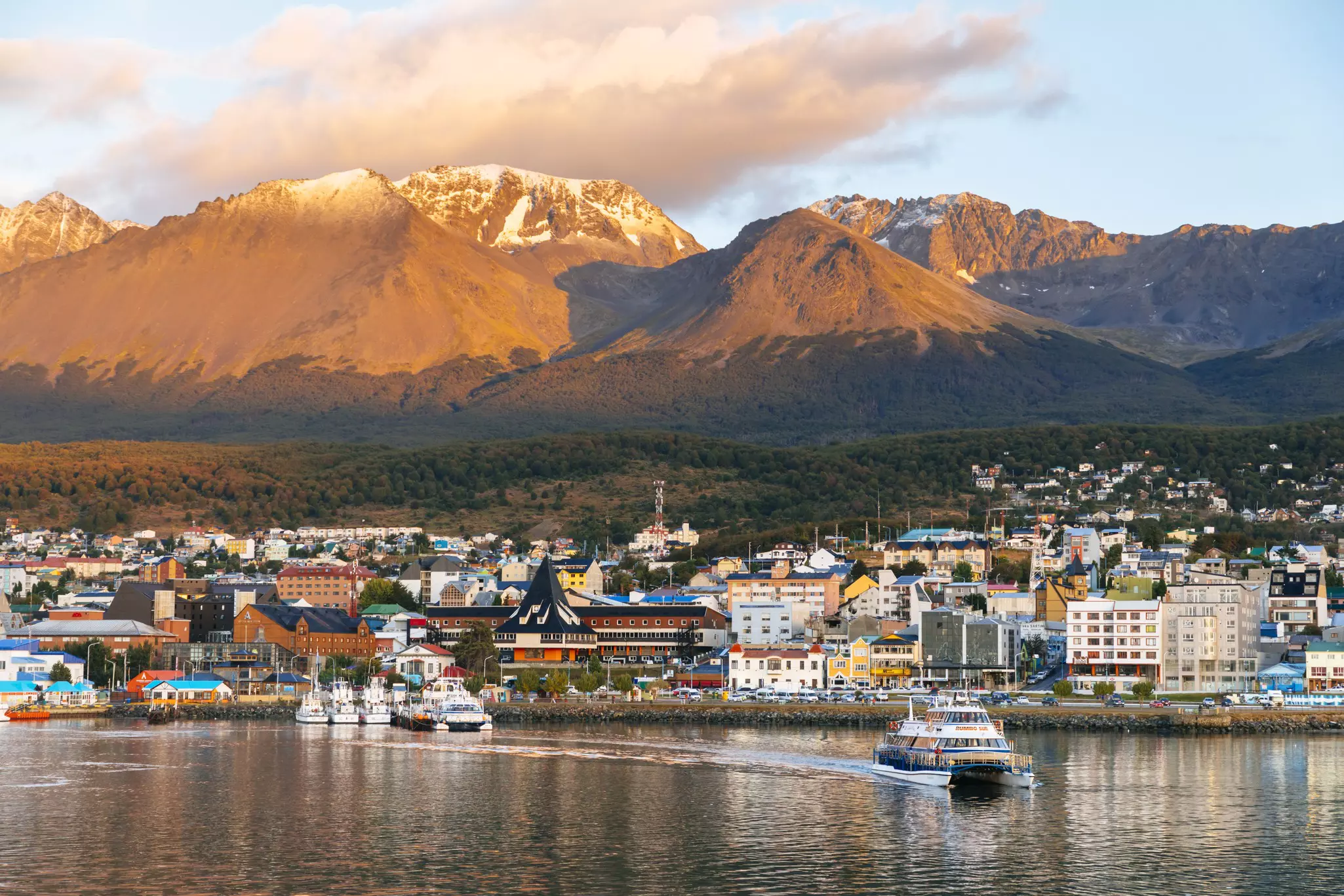 The town of Ushuaia at golden hour, with the Martial range lit up behind it